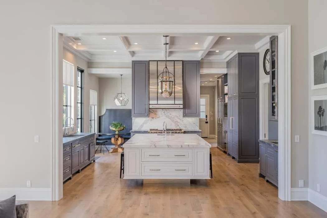 Two-tone kitchen with a white island and wood floors